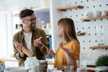 Çift evde birlikte yemek pişiriyor ve yemek hazırlıyor.