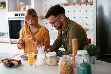 Mutlu çift evde kahvaltı yapıyor.