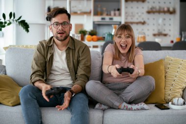 Çift evdeki kanepede oyun oynuyor.