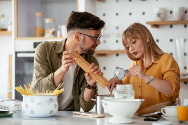 Karı koca mutfakta. Genç çift evde lezzetli yemekler hazırlıyor..