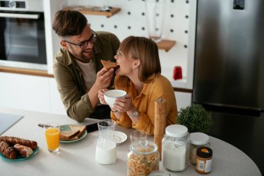 Mutlu çift evde kahvaltı yapıyor.