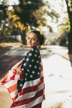 Amerikan bayrağı taşıyan genç bir kadın. 