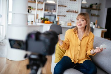 Kadın video kaydedicisi, kanalı için makyaj dersi kaydediyor. Sosyal medyada paylaşmak için makyaj dersi alan genç ve güzel bir kadın..