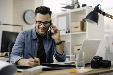 Ofis masasında oturan genç iş adamı