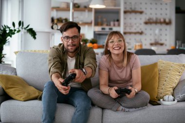 Çift evdeki kanepede oyun oynuyor.