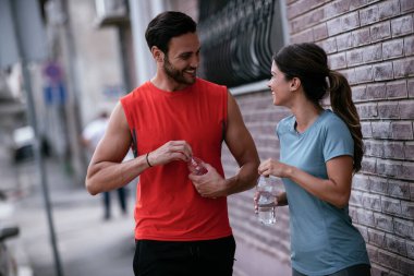 Atletik çift şehirde koştuktan sonra dinleniyor. Mutlu çift sabahları eğleniyor...