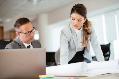 Ofiste birlikte çalışan meslektaşlar. Genç iş kadını ve işadamı yeni projede birlikte çalışıyorlar.