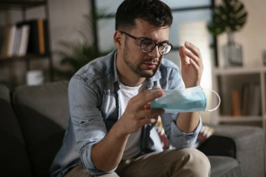 Medikal maskeli, stresli bir genç. 