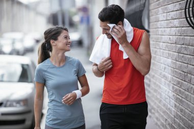 Atletik çift şehirde koştuktan sonra dinleniyor. Mutlu çift sabahları eğleniyor...