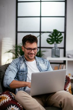 Adam evde çalışıyor, dizüstü bilgisayar kullanıyor.
