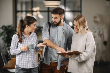Modern açık uzay ofisinde sıradan iş adamlarından oluşan bir grup. İş kadınları ve işadamları yeni proje hakkında konuşuyor.