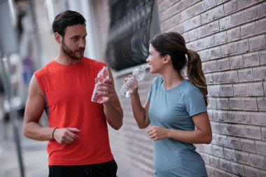 Atletik çift şehirde koştuktan sonra dinleniyor. Mutlu çift sabahları eğleniyor...