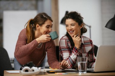 Açık uzay ofisinde konuşan ve gülen mutlu iş kadınları