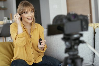 Kadın video kaydedicisi, kanalı için makyaj dersi kaydediyor. Sosyal medyada paylaşmak için makyaj dersi alan genç ve güzel bir kadın..