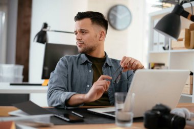 Ofis masasında oturan genç iş adamı