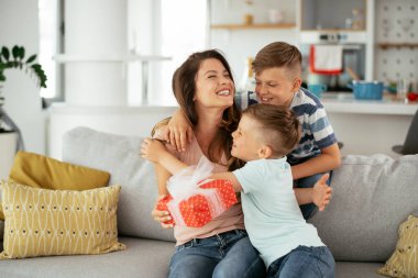 Çocuklar annelerine hediye veriyorlar.