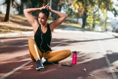 Genç bir kadın dışarıda egzersiz yapıyor. 