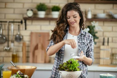 Güzel genç bayan mutfakta sebze salatası hazırlıyor..