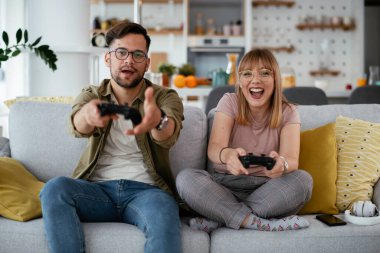 Çift evdeki kanepede oyun oynuyor.