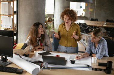 İş kadınları yeni bir proje üzerinde çalışıyor. İş arkadaşları ofiste iş tartışıyor.