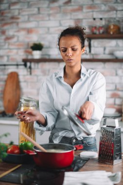 Güzel bir kadın yemek pişiriyor ve mutfakta eğleniyor. Kız mutfakta sağlıklı yemek pişiriyor..