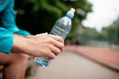 Susamış bir sporcu. Antrenmandan sonra su içen adam..