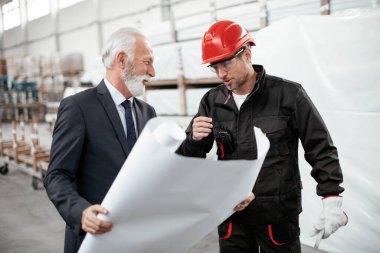 İş arkadaşları birlikte çalışıyor. Fabrikada mimar ve işçi..