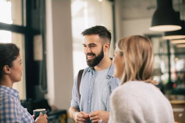 Modern açık uzay ofisinde sıradan iş adamlarından oluşan bir grup. İş kadınları ve işadamları yeni proje hakkında konuşuyor.