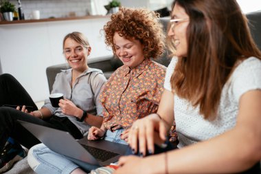 Ofiste kız arkadaşlar konuşuyor ve gülüyor. Ofiste kahve içen güzel kadınlar