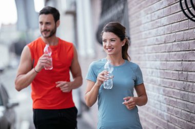 Atletik çift şehirde koştuktan sonra dinleniyor. Mutlu çift sabahları eğleniyor...