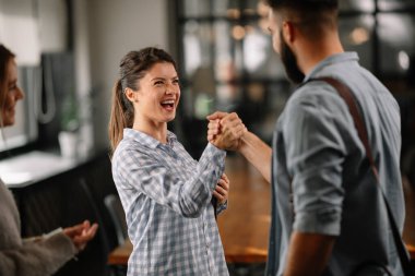 Modern açık uzay ofisinde sıradan iş adamlarından oluşan bir grup. İş kadınları ve işadamları yeni proje hakkında konuşuyor.