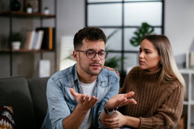 Genç adam ve kız arkadaşı oturma odasında kanepede.