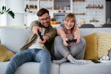 Çift evdeki kanepede oyun oynuyor.