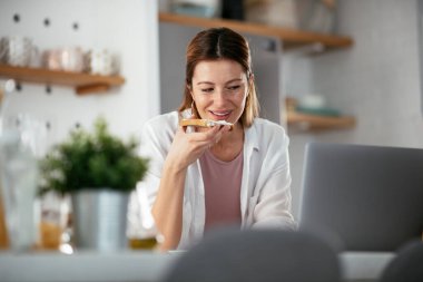 Güzel bir kadın görüntülü görüşme yapıyor. Güzel kadın evde eğleniyor..