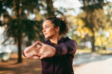 Kadın antrenmandan önce ellerini ısıtıyor.