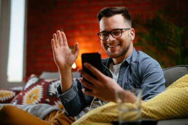Sıradan bir adamın evde telefonuyla görüntülü konuşması. Adam apartmanında sosyal medyada sohbet ediyor..