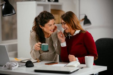Açık uzay ofisinde konuşan ve gülen mutlu iş kadınları