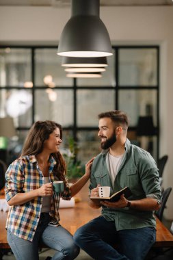 Tasarımcı, ortaklarına proje hakkında yeni fikirler veriyor. İş adamları ofiste yeni iş projelerini tartışıyor.