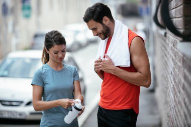 Atletik çift şehirde koştuktan sonra dinleniyor. Mutlu çift sabahları eğleniyor...