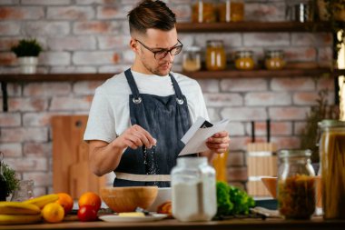Mutfakta makarna hazırlayan yakışıklı adam. Lezzetli yemek pişiren adam..