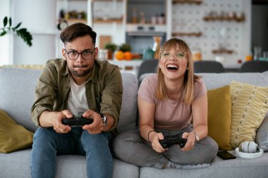 Çift evdeki kanepede oyun oynuyor.