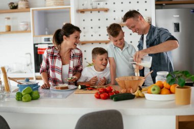 Evde genç ve mutlu bir aile yemeği. Annem ve babam oğullarımla kahvaltı hazırlıyorlar..