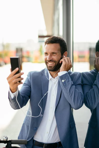 Mladý Podnikatel Obleku Poslouchat Hudbu Chytrým Telefonem Ulici — Stock fotografie