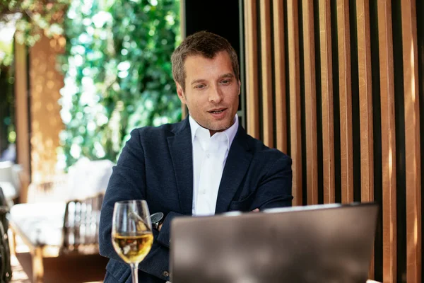 Handsome businessman dressed in the suit drinking wine. Businessman enjoying in the restaurant