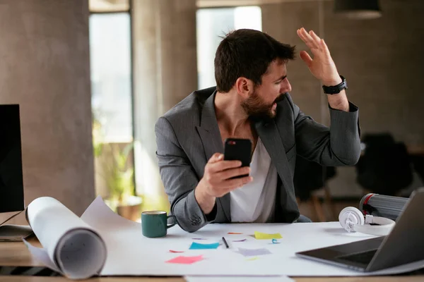 Angry businessman working on project. Young businessman working in the office.