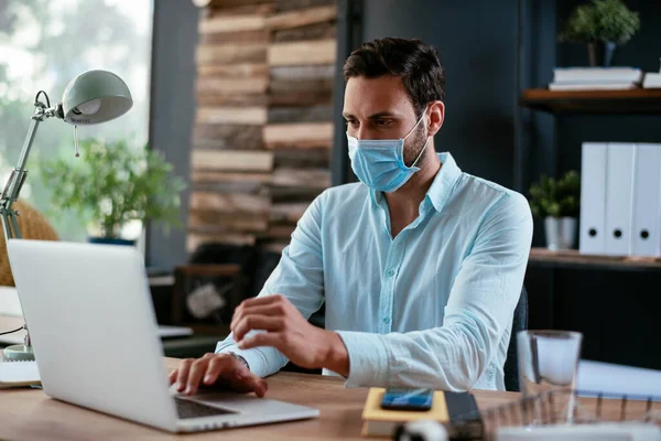 Businessmen with medical mask working in office. Businessman at his work place with medical mask. Covid-19 concept.