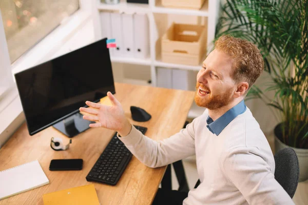 Businessman with ginger hair working in the office at his workplace