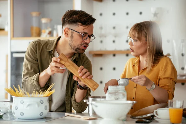 Karı koca mutfakta. Genç çift evde lezzetli yemekler hazırlıyor..