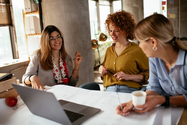 Businesswomen working on a new project. Colleagues discussing work in office.