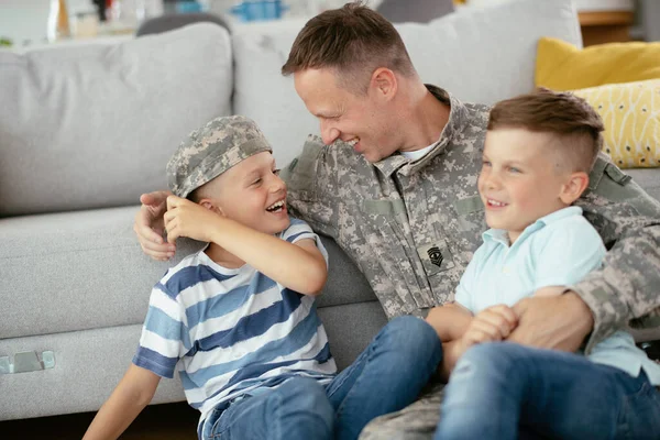 stock image Father in uniform spending time together with sons at home near sofa 